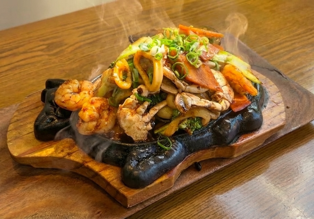 Sizzling Black Bean Plate on cast iron with steam rising · Korean-Vietnamese fusion with Hung Cheong salted black beans, Pho Heaven Westgate